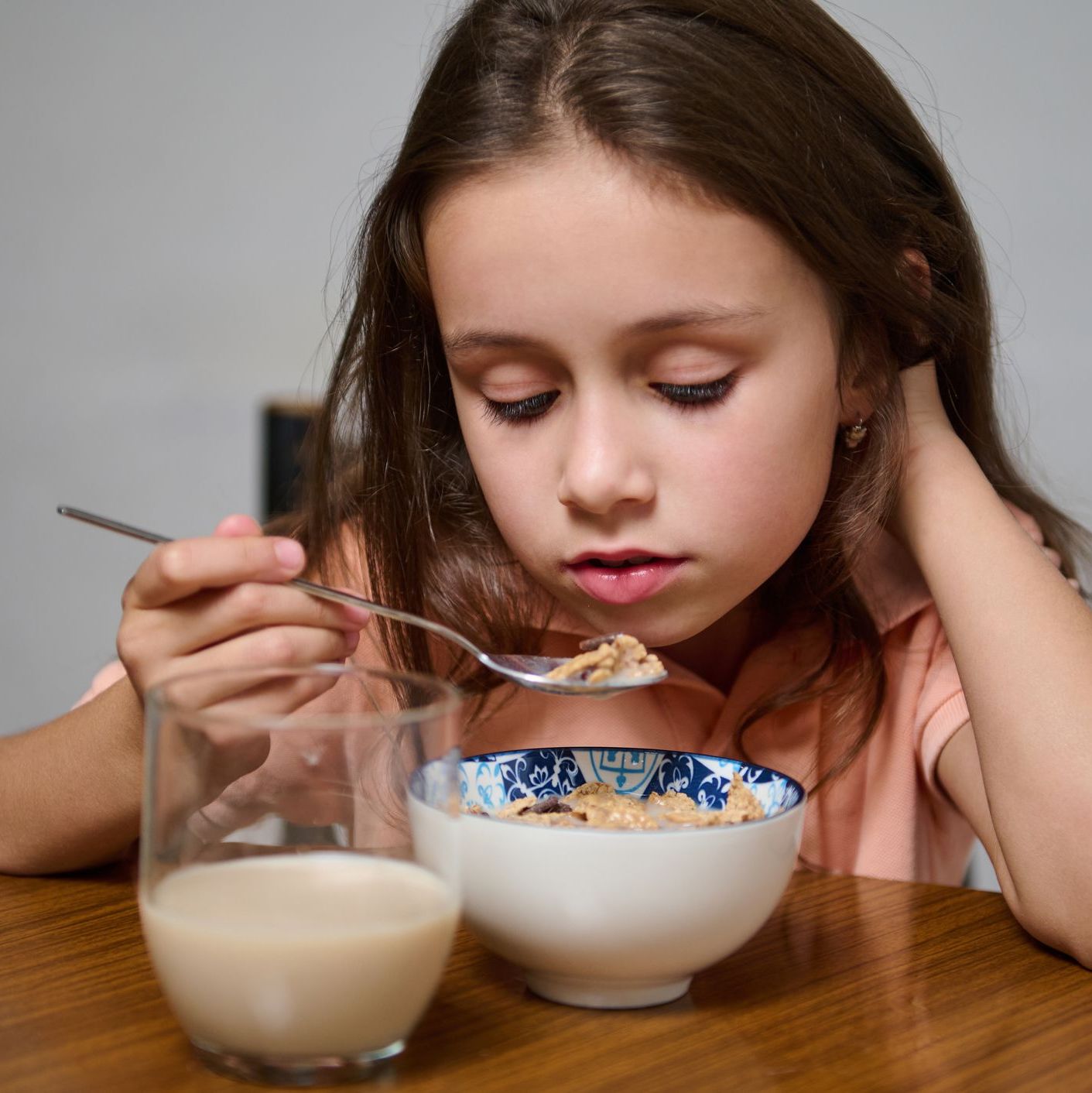 Young girl enjoying a healthy breakfast with cereal and milk